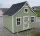 Sage green variant of the Little Cottage Company Gingerbread Cottage Playhouse with heart-shaped window and contrasting white trim.