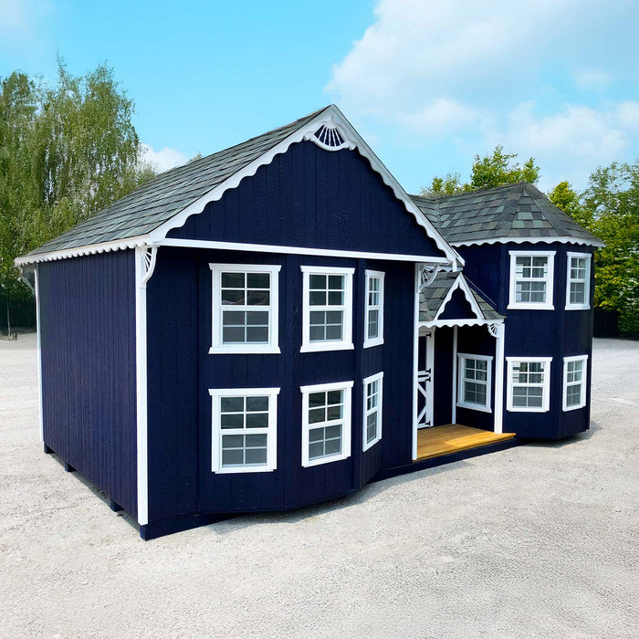 Exterior of Sara’s Victorian Mansion playhouse by Little Cottage Co. in dark navy with white trim, showing front porch and turreted corner design