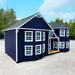 Exterior of Sara’s Victorian Mansion playhouse by Little Cottage Co. in dark navy with white trim, showing front porch and turreted corner design