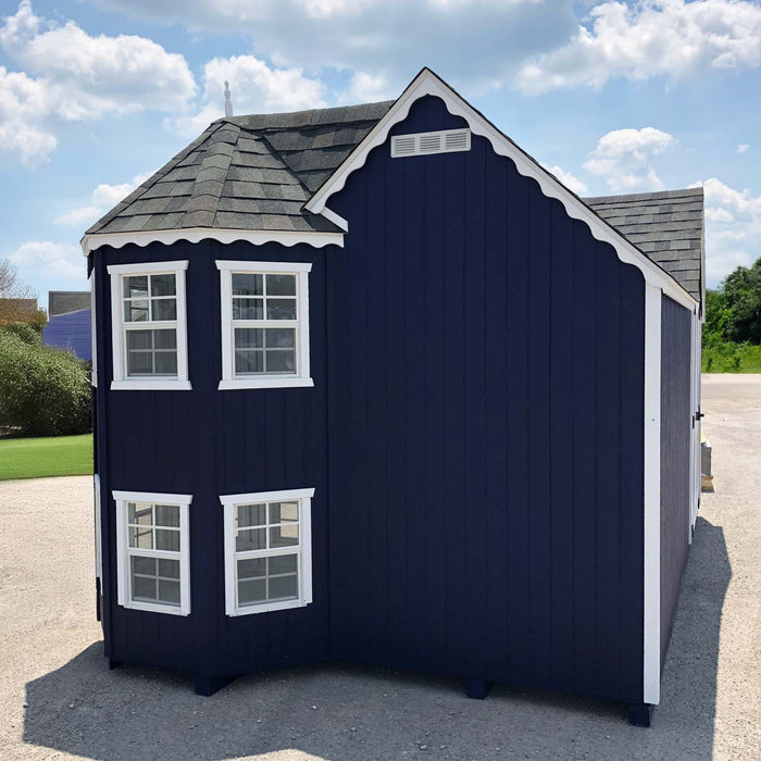 Side view of Sara’s Victorian Mansion playhouse by Little Cottage Co. in navy blue with white trim and multiple windows for natural light