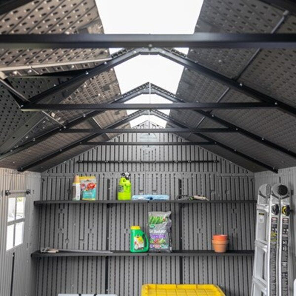 Interior view of the Lifetime dual entry storage shed showing the ridge skylight, shelving, and a ladder stored inside.