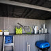 Close-up of the Lifetime Modern Shed's interior shelf with tennis balls, a racket, and a watering can.