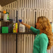 Woman reaching for a spray bottle on the Lifetime storage shed's interior shelving.