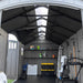 Wide interior view of the Lifetime dual entry storage shed showing skylights, shelving, ladder, and a mower stored inside.