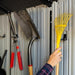 Close-up of the Lifetime storage shed's interior wall hooks holding a shovel, shears, and rake.