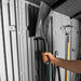 Close-up of the Lifetime storage shed's interior wall hooks holding a shovel and garden tools.