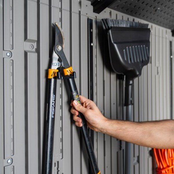 Close-up of the Lifetime storage shed's interior wall hooks holding pruning shears and a broom.