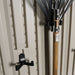 Close-up of a rake mounted on the Lifetime storage shed's interior wall hook.