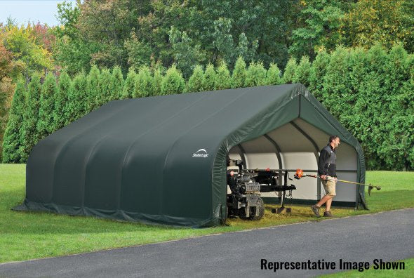 Large green ShelterLogic tent with a peak roof sitting on a lush green field next to a gravel driveway. 