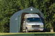 ShelterLogic detached garage with a green gambrel roof storing a large RV. This portable garage has a steel frame and fabric cover, providing protection for oversized vehicles.