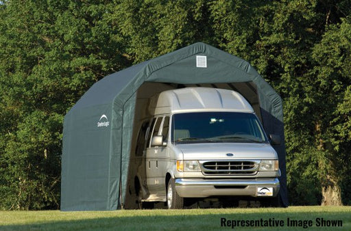 Green ShelterLogic ShelterCoat with gambrel roof and RV parked inside with trees in the back