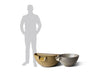 A person stands next to two Slick Rock Concrete Spill Water Bowls, showcasing the difference in size between the Classic large (tan) and the Classic size (gray).