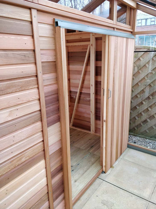 Close-up of the sliding door of the Alton Cedar Fusion Greenhouse, highlighting the wooden panels and metal track.