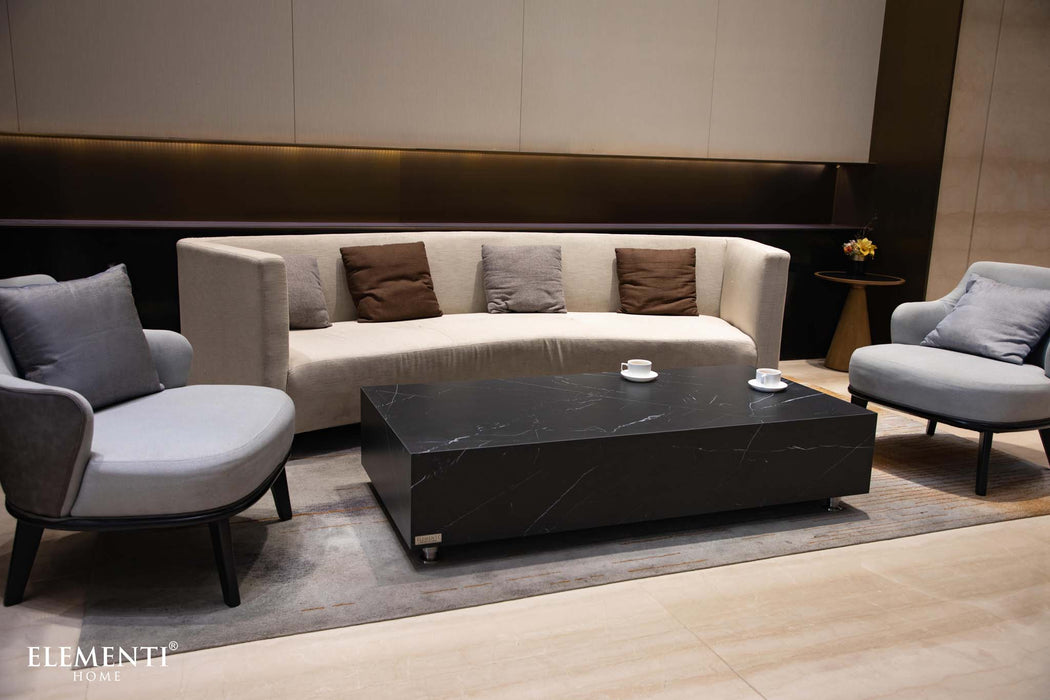 Living room setting featuring the Elementi Marble Porcelain Series Rectangle Coffee Table in Bulgaria Black, along with a curved sofa and armchairs.