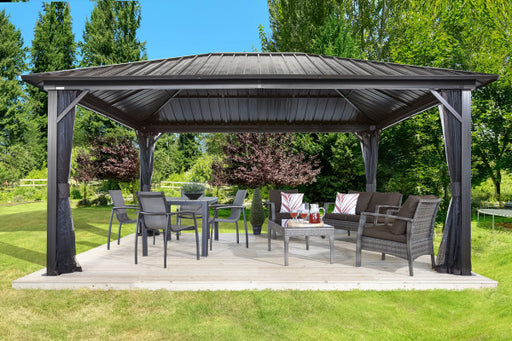 Sojag Genova Gazebo 12 x 16 ft with mosquito netting, couch, and dining set for outdoor use.