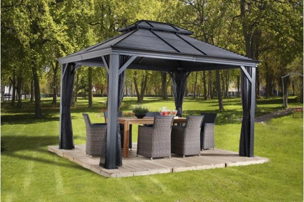 Dark Gray Sojag Mykonos II Double Roof Aluminum Gazebo 10x14 with an outdoor dining set on a wooden deck in a backyard setting