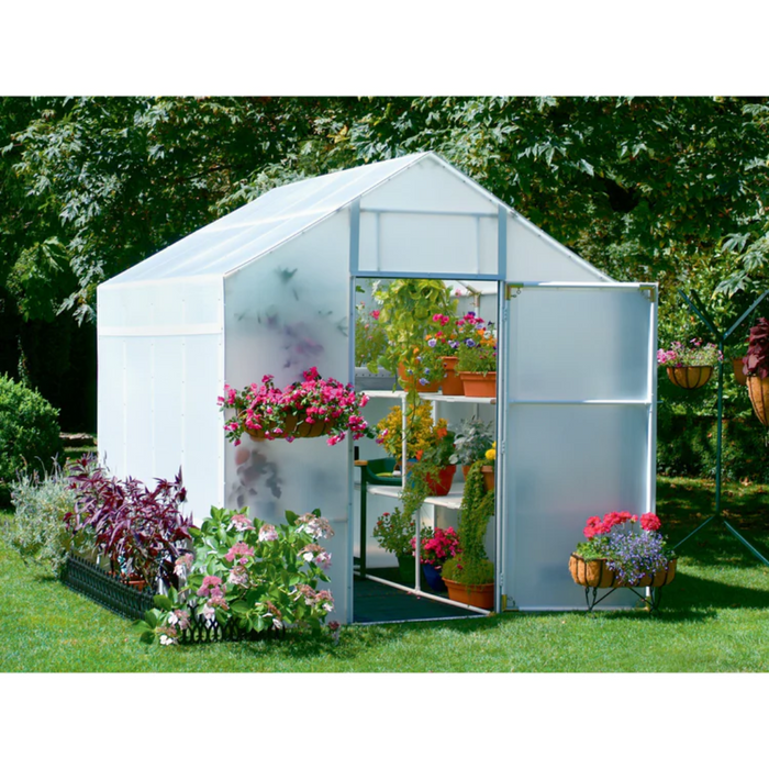 Solexx Garden Master Greenhouse with colorful floral arrangements and plants on shelves, set in a lush garden