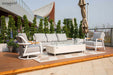 An Elementi Outdoor Furnitures Santorini Collection lounge set, featuring a sofa, two chairs, and a central fire table on a wooden deck.