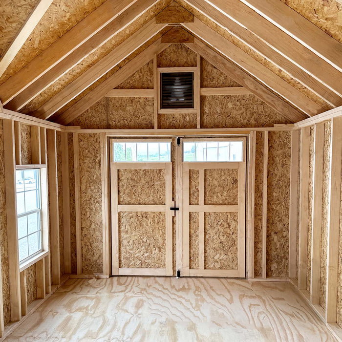 Sunlit Star Barn interior showing high wooden rafters, vent above transom doors, and smooth plywood flooring by Little Cottage Co.