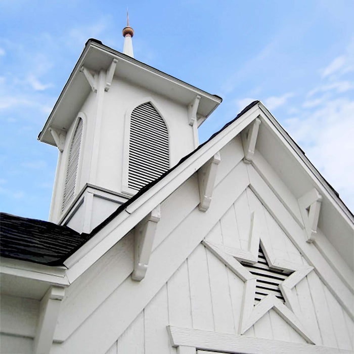 Detailed view of the Star Barn’s steeple cupola showing decorative trim, louvered vents, and copper spire accent above gray roof shingles.