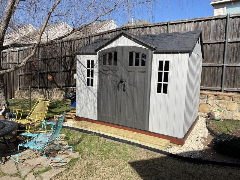 Lifetime 10x8 ft. storage shed installed on a backyard patio, side angle view with closed doors.