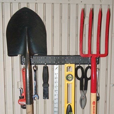 Close-up of the Lifetime storage shed's interior wall hooks holding a shovel, pitchfork, and garden tools.
