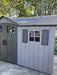 Exterior close-up of the Lifetime storage shed's side entry door and window with decorative shutters.