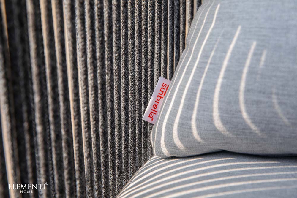 Detailed view of Sunbrella fabric label on Elementi Capri Collection outdoor cushion, highlighting durable fabric and intricate woven rope backing.