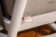 A close-up of a Sunbrella fabric tag on a light brown cushion, part of the Elementi Santorini Collection outdoor furniture.