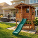 Sunflower Playhouse 6x9 with sandbox next to a patio seating area and outdoor grill
