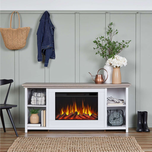 Real Flame Tramore white electric fireplace TV stand in a farmhouse entryway with sage green paneled wall, decorative vases, wire baskets, black chair, and coats on hooks