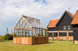 Alton Cheltenham Victorian Greenhouse near modern barn-style buildings.