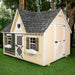 Front view of Little Cottage Co. Victorian Cozy Kennel with yellow siding, heart gable, and green shutters on grassy lawn