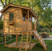 Front view of the Western Red Cedar Cozy Cabin Playhouse by Outdoor Living Today, showing covered porch, window flower box, and climbing wall