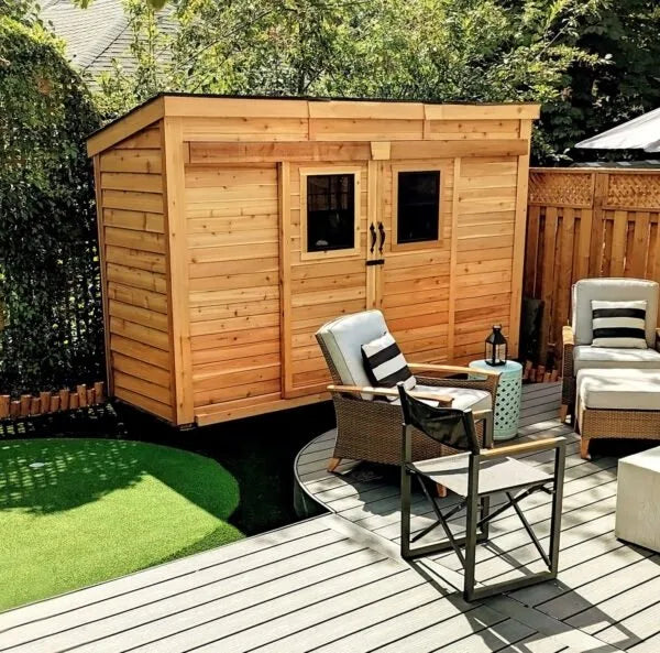GardenSaver 12x4 Western Red Cedar Shed installed beside deck seating area with sliding doors and dual windows.