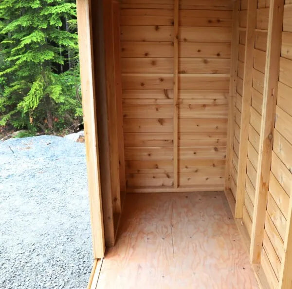 Spacious interior of GardenSaver 12x4 cedar shed with natural wood walls, plywood floor, and open doorway for easy access.