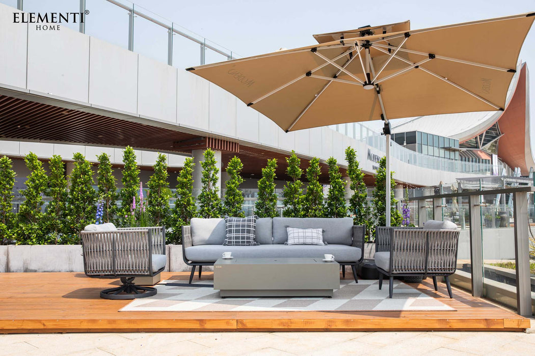 wide-angle shot of a complete Elementi Milano Collection outdoor lounge set featuring a light grey sofa with accent pillows, two grey rope armchairs with light cushions