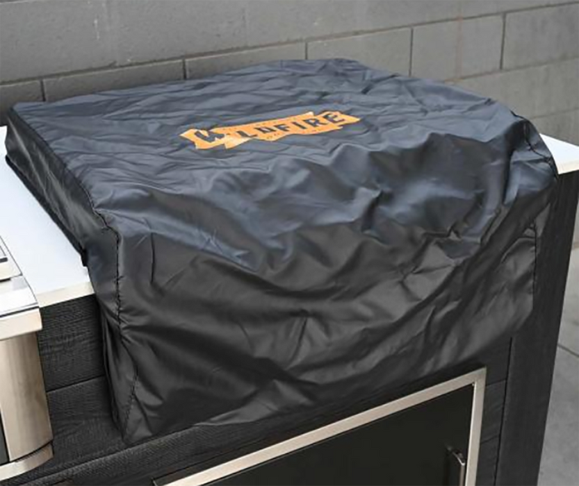 Close-up of the Wildfire Ranch Pro built-in griddle protected with a black custom-fitted cover showcasing the Wildfire logo