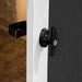 Close-up of a partially open door with a black latch and weather-resistant handle on the Handy Home Windemere 10x12 - Wood Storage Shed.