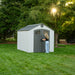 Woman opening the gray door of the Lifetime 8x10 Shed in a beautifully lit garden setting.