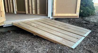 Wooden entry ramp attached to Ez-Fit Skyview Shed Kit providing easy access for lawn equipment and storage items.