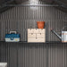 A Lifetime 20 Ft. X 8 Ft. Outdoor Storage Shed - 60351 with a potted plant and a watering can.
