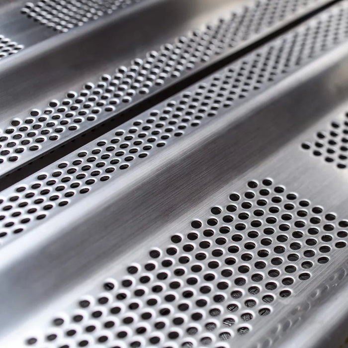  A close-up view focusing on the perforated design of the stainless steel cooking grates on a gas grill.