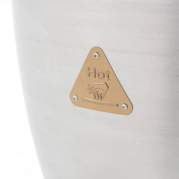 Image of the safety warning plate on a Blaze Grills 20-inch Kamado Grill, with a "Hot" caution and hand symbol in a triangular brass-colored badge.
