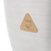 Image of the safety warning plate on a Blaze Grills 20-inch Kamado Grill, with a "Hot" caution and hand symbol in a triangular brass-colored badge.
