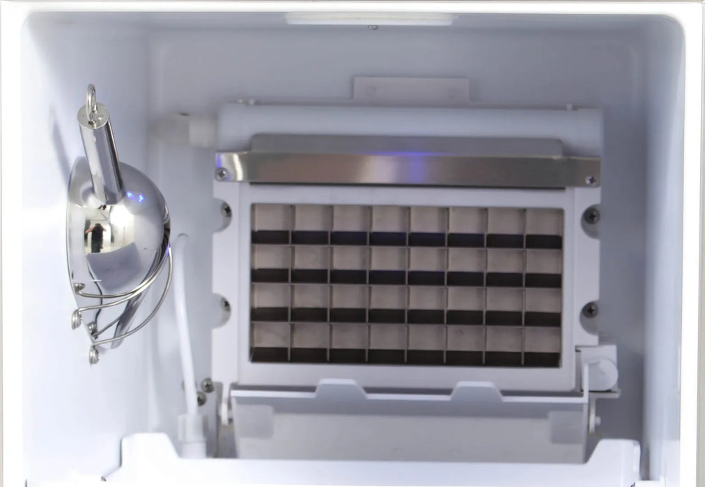 Interior view of the Blaze Grills Outdoor Ice Maker featuring the metal ice-making grid, with a scoop hanging on the side.