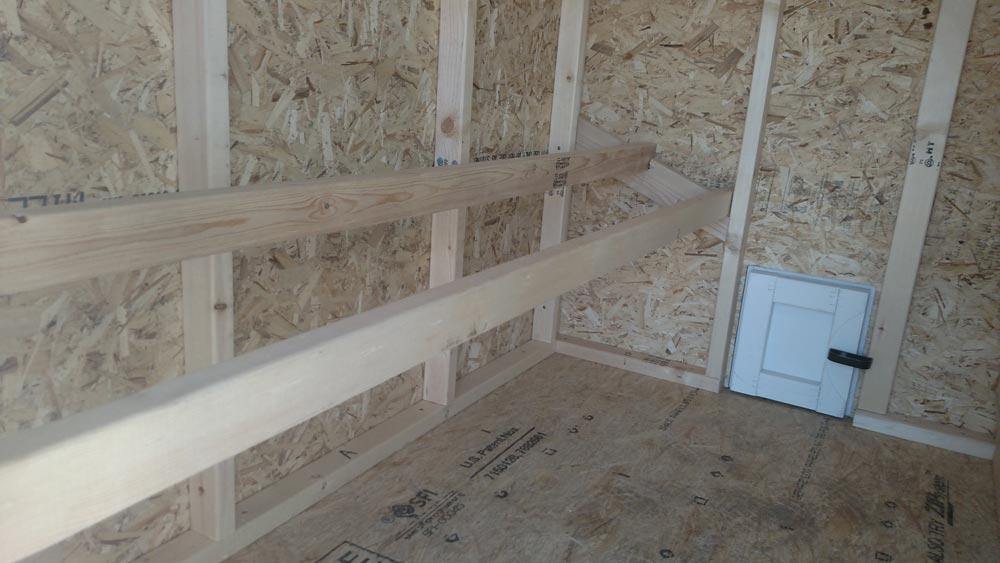 Inside view of the roosting area within the Large OverEZ Chicken Coop showing wooden perches and ample space for up to 15 chickens.