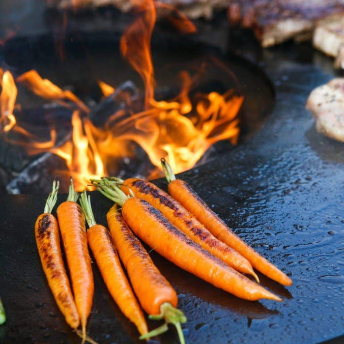 Char-grilled carrots on the Arteflame Classic 40" Grill, emphasizing the even heating cooktop.