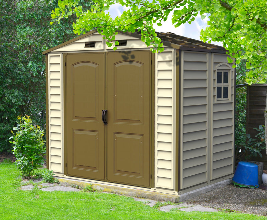 Duramax StoreAll 8'x6' Vinyl Shed with Foundation in a lush garden setting, showcasing robust double doors and a sturdy build.