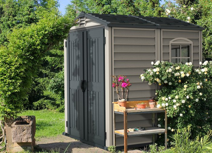 Duramax 6x6 StoreMate Plus Vinyl Shed w/floor - Backyard Oasis placed in the garden; side view